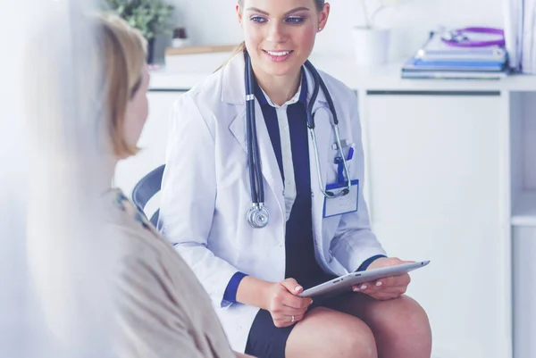 Médico e paciente discutindo algo enquanto se senta na mesa. Conceito de medicina e cuidados de saúde — Fotografia de Stock