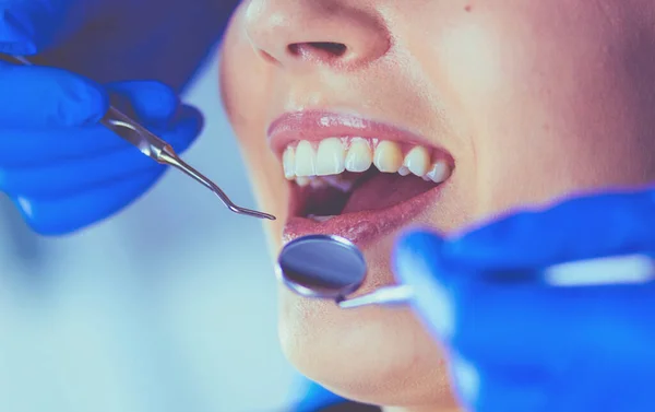 Mujer joven con la boca abierta examinando la inspección dental en el consultorio del dentista. — Foto de Stock