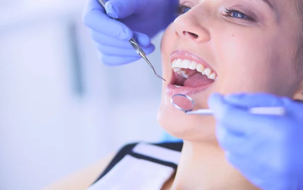 Mujer joven con la boca abierta examinando la inspección dental en el consultorio del dentista. — Foto de Stock