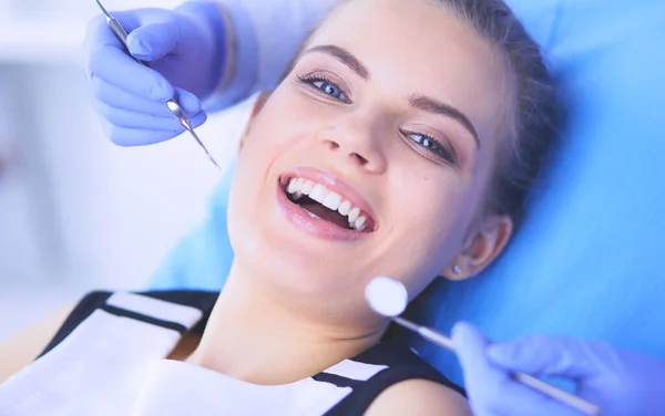 Mujer joven con la boca abierta examinando la inspección dental en el consultorio del dentista. — Foto de Stock