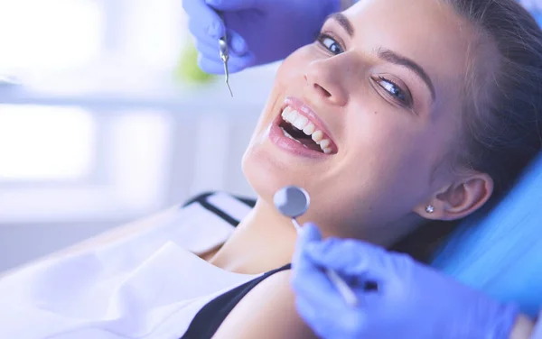 Mujer joven con la boca abierta examinando la inspección dental en el consultorio del dentista. — Foto de Stock