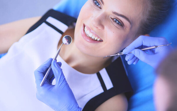 Young Female patient with pretty smile examining dental inspection at dentist office.