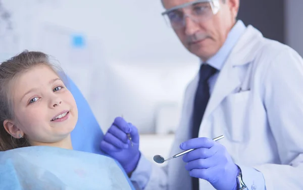 Kleines Mädchen sitzt in der Zahnarztpraxis — Stockfoto