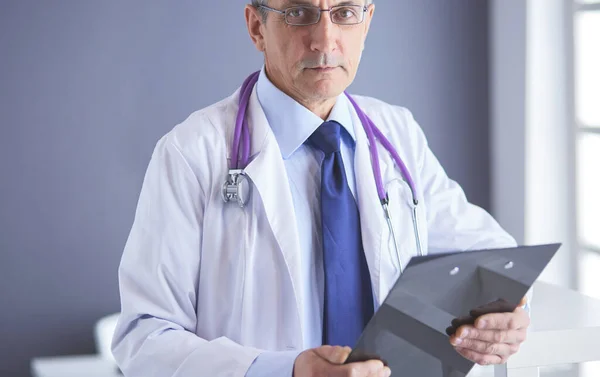 Homme médecin écrit des notes sur le presse-papiers à l'hôpital — Photo