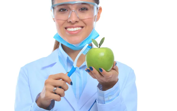 Dentista médico mulher segurar maçã fresca verde na mão e escova de dentes — Fotografia de Stock