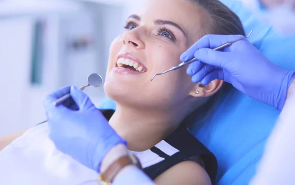 Ung kvinnlig patient med öppen mun undersöker tandläkarundersökning på tandläkarmottagningen. — Stockfoto