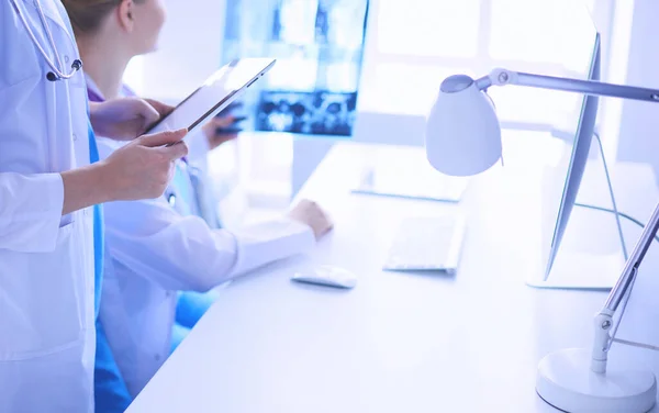 Close-up tiro de médico com tablet e colega com raio-x em segundo plano. — Fotografia de Stock