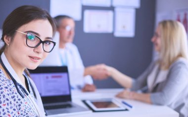 Doktor ve hasta masada otururken bir şey tartışıyorlar. İlaç ve sağlık hizmetleri kavramı