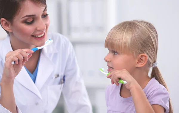 Dentista y niña en el consultorio del dentista. — Foto de Stock