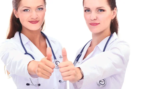 Dvě mladé ženy doktor ukazuje ok, stojící v nemocnici — Stock fotografie