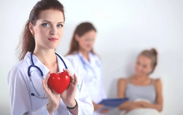 Female doctor with stethoscope holding heart — Stock Photo, Image