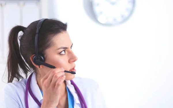 Dokter draagt een headset zittend achter een bureau met laptop — Stockfoto