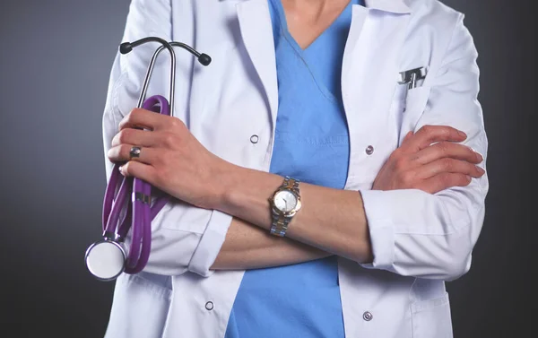 Portrait of young female doctor holding a stethoscope, isolated on black background — Stock Photo, Image