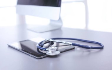 Tıbbi ekipman: Beyaz arka planda mavi steteskop ve tablet. Tıbbi ekipman