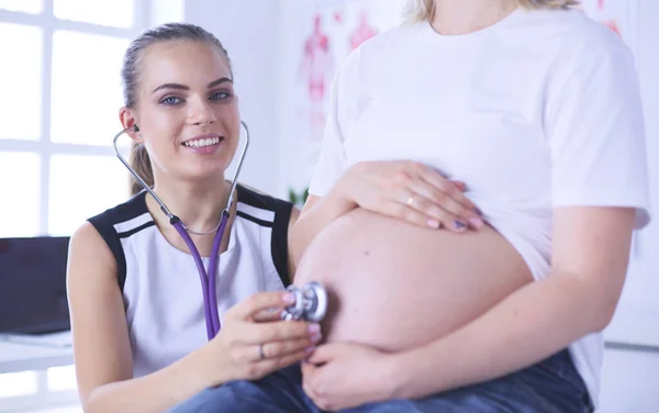 Genç bayan doktor klinikte hamile kadını muayene ediyor.. — Stok fotoğraf