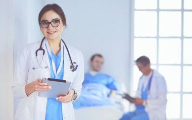 Hastane lobisinde tablet bilgisayar kullanan kadın doktor.