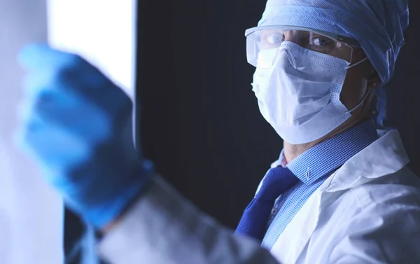 Joven médico buscando imagen de rayos X sobre fondo blanco aislado — Foto de Stock