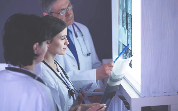 Bir grup doktor bir klinikte röntgenleri inceliyor, teşhis koymayı düşünüyorlar. — Stok fotoğraf