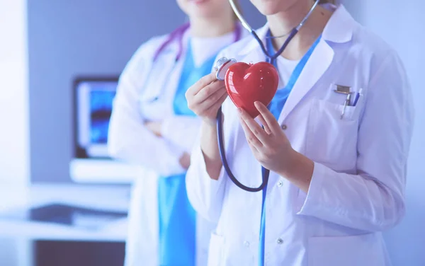 Cultivado brote de dos médicos jóvenes mujer con estetoscopio celebración del corazón. — Foto de Stock