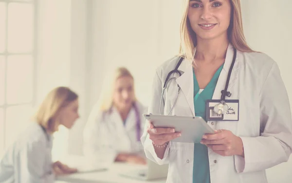 Portrait of a young female doctor, with aipads in hand, in a medical office — Stock Photo, Image