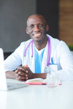 Masada dizüstü bilgisayarla çalışan genç bir Afrikalı doktor. Doktor bey. İşyeri