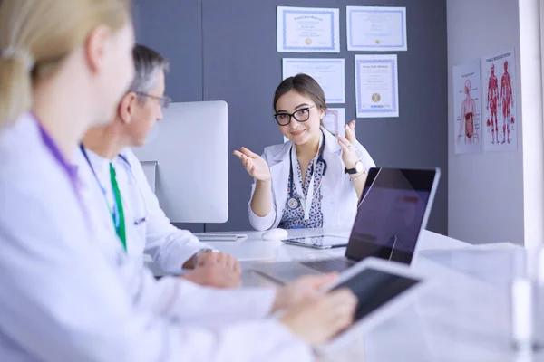 Serious medical team using a laptop in a bright office — Stock Photo, Image