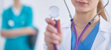 Steteskoplu kadın doktor dinliyor.