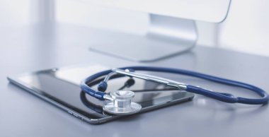 Tıbbi ekipman: Beyaz arka planda mavi steteskop ve tablet. Tıbbi ekipman