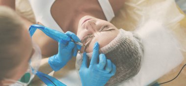 Kaşlar için kalıcı makyaj. Güzellik salonunda kalın kaşlı güzel bir kadın..