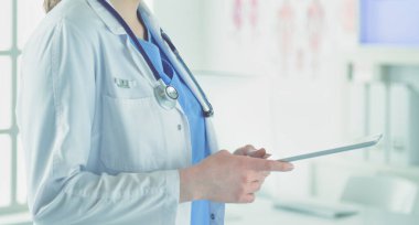 Hastane lobisinde tablet bilgisayar kullanan kadın doktor.