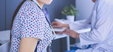 Parlak bir ofiste konuşan iki doktor.