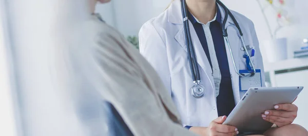 Docteur et patient discutant de quelque chose assis à la table. Médecine et soins de santé concept — Photo