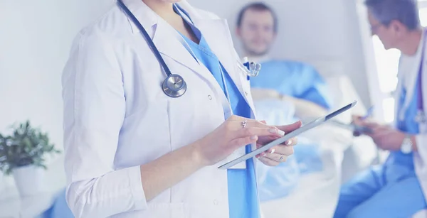 Female doctor using tablet computer in hospital lobby