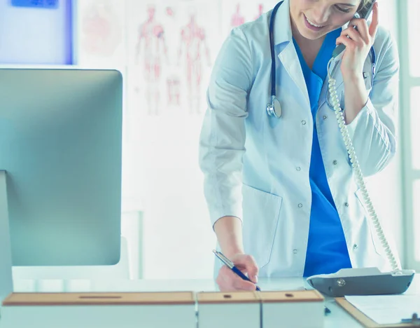 Seriöse Ärztin telefoniert in ihrem Büro — Stockfoto