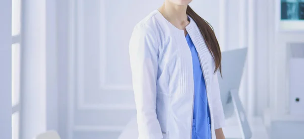 Portrait of young woman doctor in white coat standing in hospital — Stock Photo, Image