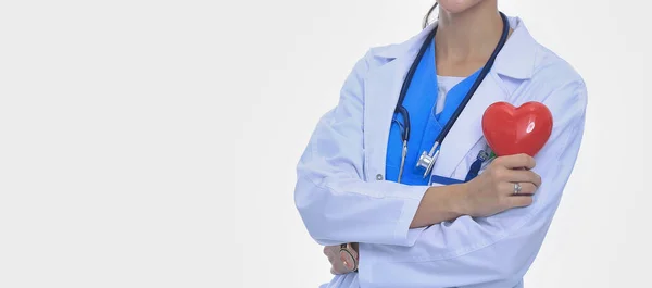 Médica feminina positiva em pé com estetoscópio e símbolo de coração vermelho isolado. Mulher médica — Fotografia de Stock