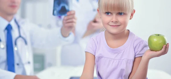 Child and medicine concept - female doctor giving an apple to little girl — Stock Photo, Image