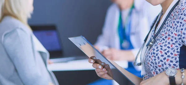 Dottore e paziente discutono di qualcosa mentre sono seduti al tavolo. Medicina e concetto di assistenza sanitaria — Foto Stock