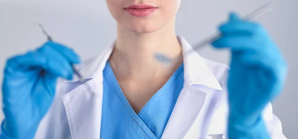 Attractive female dentist with tools , standing on gay background — Stock Photo, Image