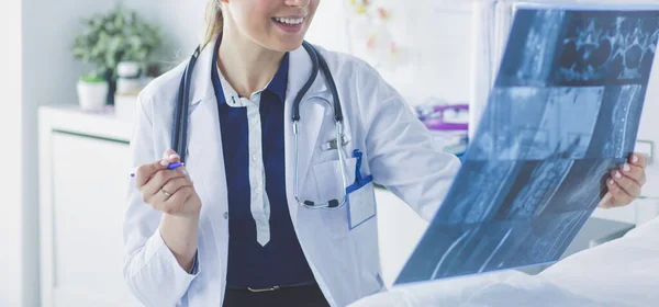 Giovane attraente medico femminile guardando l'immagine a raggi X — Foto Stock