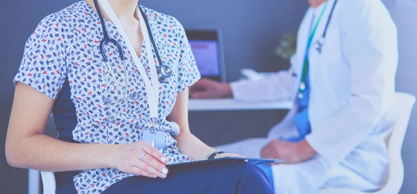 Bir doktor ekibi, kadın ve erkek, ofiste bekliyorlar.