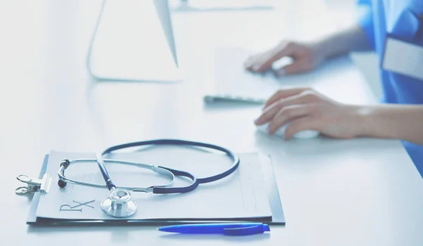 Doctora sentada en el escritorio y trabajando en un portátil en el hospital —  Fotos de Stock