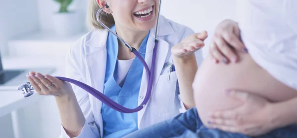 Ung kvinna läkare med stetoskop tala med gravida kvinna på sjukhus. — Stockfoto