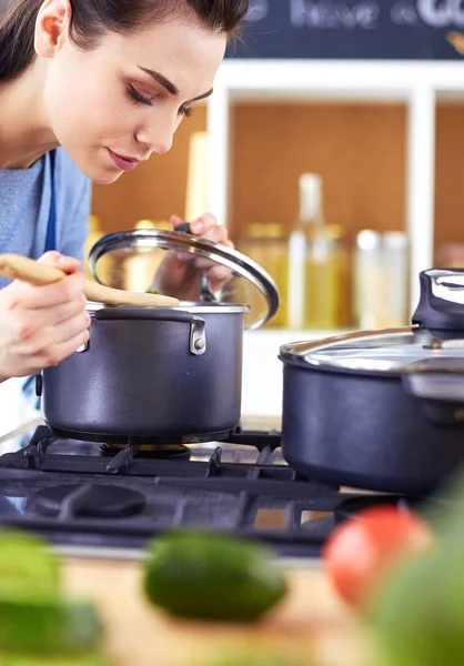 Cuisson femme dans la cuisine avec cuillère en bois — Photo