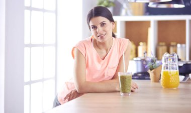 Mutfakta masada oturan genç bir kadın.