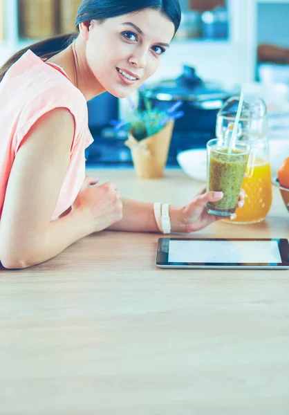 Mutfakta dijital tablet kullanan güzel genç bir kadın. — Stok fotoğraf