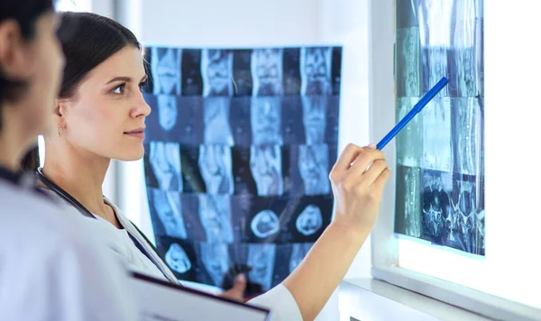 Two female doctors pointing at x-rays in a hospital — Stock Photo, Image