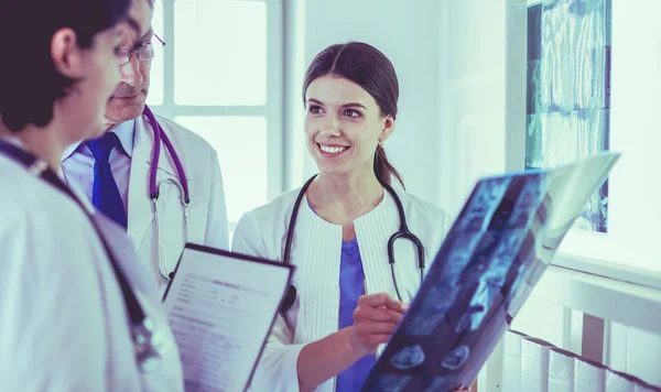 Lächelnde Ärzte diskutieren die Diagnose ihrer Patienten beim Röntgen im Krankenhaus — Stockfoto