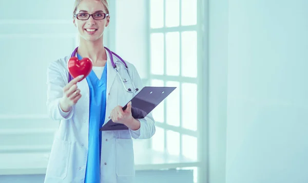 Female doctor with the stethoscope holding heart — Stock Photo, Image