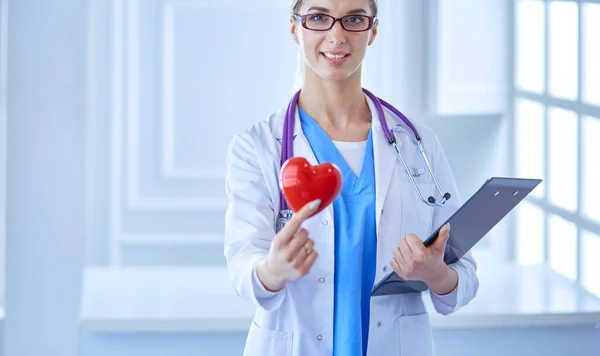 Médica com o estetoscópio segurando o coração — Fotografia de Stock